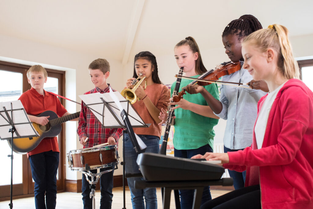 a group of youths playing orchestra instruments together