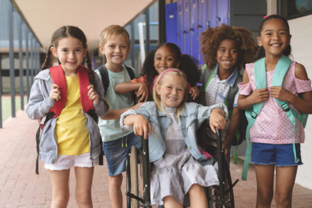 a group of elementary students smiling in the school hallway